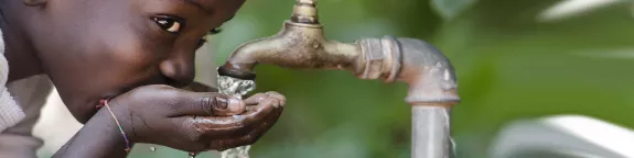 Child drinking water from a tap