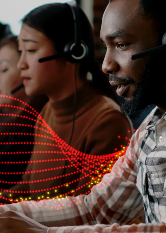 Multiple people working in a call centre talking through headsets