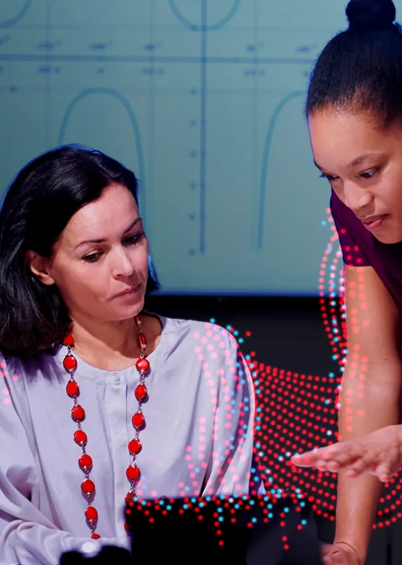 Four people talking whilst looking at a Lenovo ThinkPad Laptop