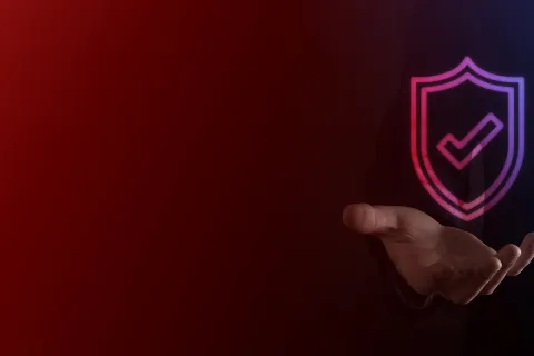 Ticked cybersecurity badge in businessman’s hand.